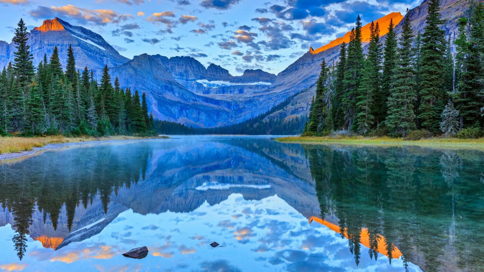An alpine lake reflecting Montana's peaks at sunrise
