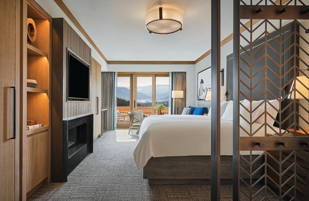 A guest room with a fireplace and a terrace facing the mountains
