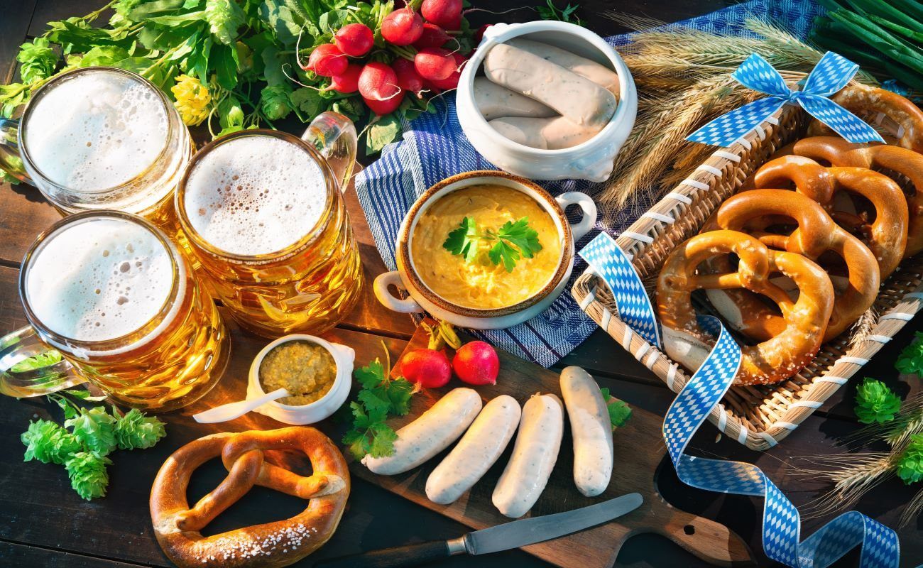 Weißwurst, Brezn, Obatzda and Maß on a wooden table